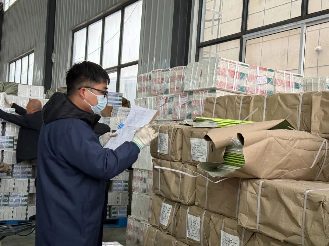 2026年3月2日固安县新华书店仓库内工作人员对照清单,逐一核对教学用书的种类与数量.jpg
